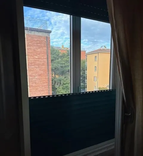 Tapparella in PVC scura abbassata a metà su una finestra – sostituzione tapparelle a Vo'